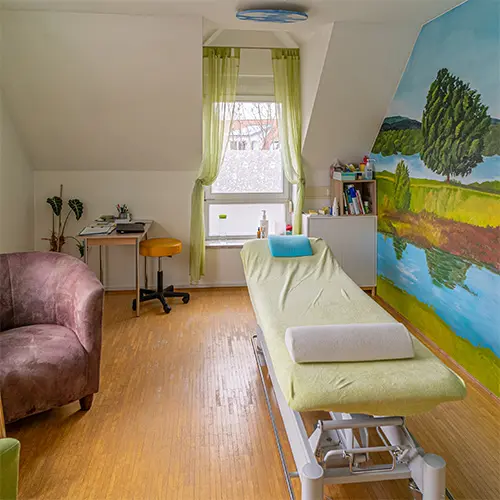 Behandlungsraum der Osteopathie Praxis Vita Neumarkt mit farbigem Wandbild